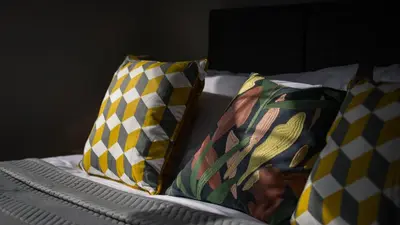 three pillows sitting on a bed in a room at Altham Place-Free Parking Space in Morecambe