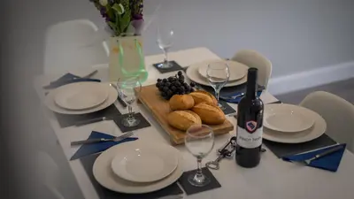 a table with plates and glasses of wine and bread at Altham Place-Free Parking Space in Morecambe