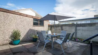 a table and chairs with an umbrella on a patio at Altham Place-Free Parking Space in Morecambe