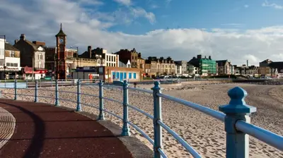 a fence on a beach with a clock tower at Altham Place-Free Parking Space in Morecambe