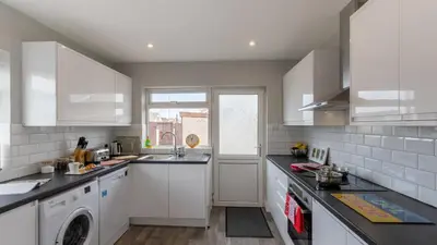 a white kitchen with a sink and a dishwasher at Altham Place-Free Parking Space in Morecambe