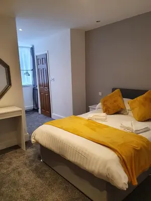 a bedroom with a large bed with a yellow blanket at Imperial view in Blackpool
