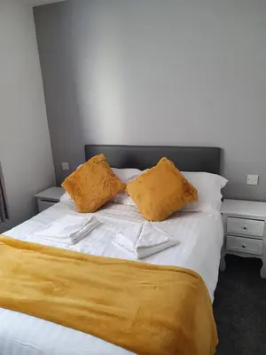 a bed with two yellow pillows on top of it at Imperial view in Blackpool