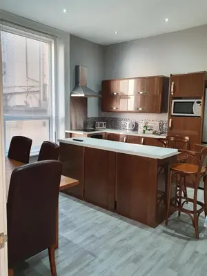 a kitchen with wooden cabinets and a table and chairs at Imperial view in Blackpool