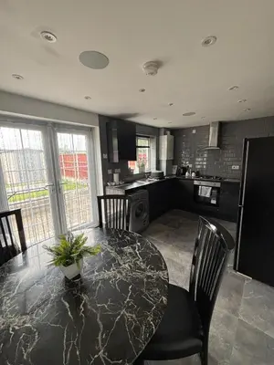 a kitchen with a table and chairs and a counter top at 2 bed house sleeps 4-5 in Liverpool