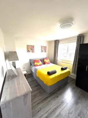 a bedroom with a large bed with yellow sheets at 2 bed house sleeps 4-5 in Liverpool