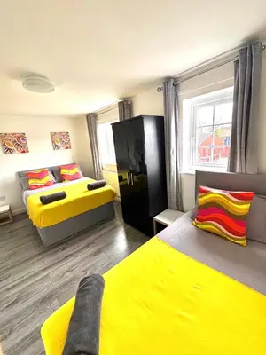 a room with two beds with yellow sheets at 2 bed house sleeps 4-5 in Liverpool