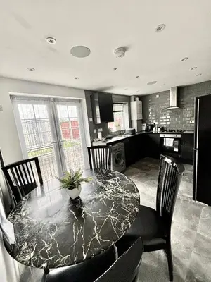 a dining room with a table and chairs and a kitchen at 2 bed house sleeps 4-5 in Liverpool