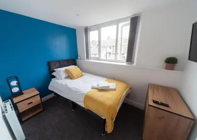 a small bedroom with a bed and a window at Beautiful 7 bed home, ideal for groups, sleeps 11! in Morecambe