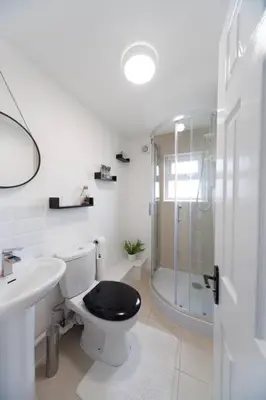 a bathroom with a toilet and a sink and a shower at Beautiful 7 bed home, ideal for groups, sleeps 11! in Morecambe