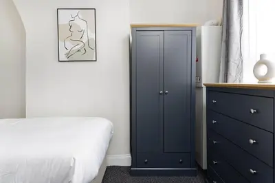 a bedroom with a blue cabinet and a bed at Toft House - Air Host & Stay - Free Parking - Contractor Friendly in Liverpool