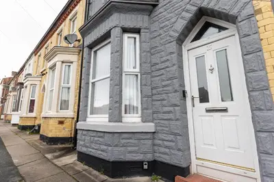 a row of houses with white doors on a street at Toft House - Air Host & Stay - Free Parking - Contractor Friendly in Liverpool