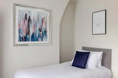 a bedroom with a bed and a painting on the wall at Toft House - Air Host & Stay - Free Parking - Contractor Friendly in Liverpool