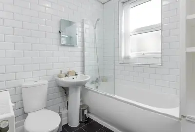 a white bathroom with a sink and a toilet and a tub at Toft House - Air Host & Stay - Free Parking - Contractor Friendly in Liverpool
