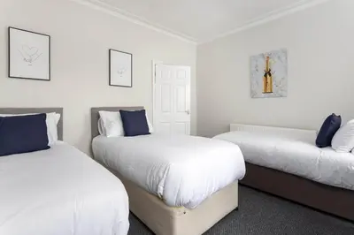 two beds in a room with white walls and blue pillows at Toft House - Air Host & Stay - Free Parking - Contractor Friendly in Liverpool