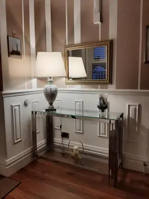 a glass table with a lamp and a mirror at Lytham Luxury in Saint Annes on the Sea