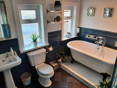 a bathroom with a tub and a toilet and a sink at Lytham Luxury in Saint Annes on the Sea