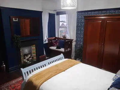 a bedroom with a white bed and blue walls at Lytham Luxury in Saint Annes on the Sea