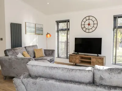 a living room with two couches and a flat screen tv at Watch Tree Lodge in Grange Over Sands
