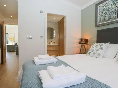 a bedroom with a bed with towels on it at Watch Tree Lodge in Grange Over Sands