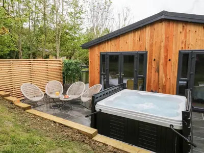a hot tub in the backyard of a house at Watch Tree Lodge in Grange Over Sands