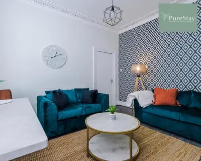 a living room with two blue couches and a table at Perfect Contractor House in Liverpool with 7 Beds By PureStay - 14 nights min! in Liverpool