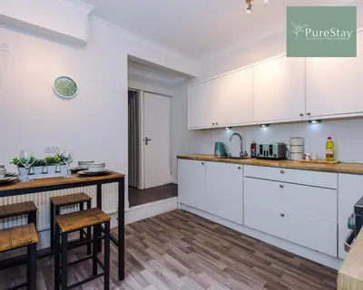 a kitchen with white cabinets and a counter top at Perfect Contractor House in Liverpool with 7 Beds By PureStay - 14 nights min! in Liverpool