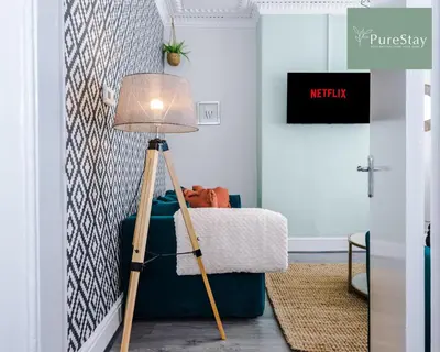 a floor lamp in a living room with a couch at Perfect Contractor House in Liverpool with 7 Beds By PureStay - 14 nights min! in Liverpool
