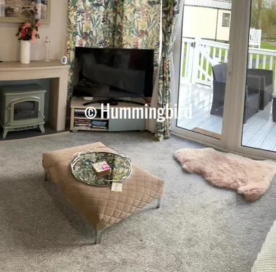 a living room with a television and a coffee table at Hummingbird Retreat in Blackpool