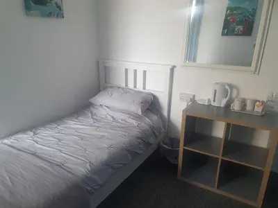 a small bedroom with a bed and a night stand at Maydene Hotel in Blackpool