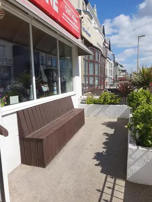 a store front with a bench in front of it at Maydene Hotel in Blackpool