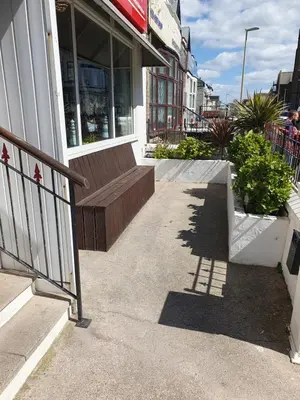 a store front with a bench in front of a building at Maydene Hotel in Blackpool