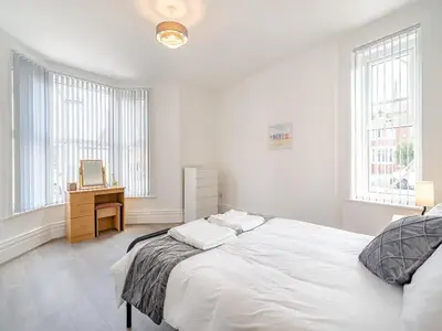 a white bedroom with a bed and a desk at One - Uk43696 in Saint Annes on the Sea