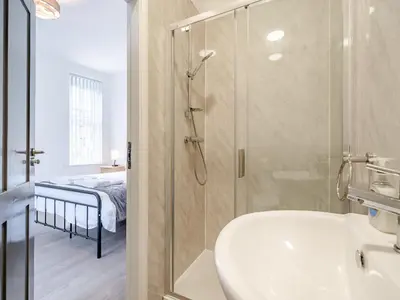 a bathroom with a shower and a sink and a bed at One - Uk43696 in Saint Annes on the Sea