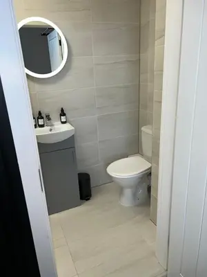 a bathroom with a toilet and a sink and a mirror at 128 Anfield Road in Liverpool