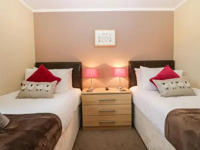 two beds in a room with two lamps on a night stand at Walkers Rest in Carnforth