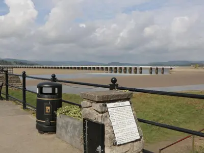 a fence with a sign in front of a pier at Walkers Rest in Carnforth
