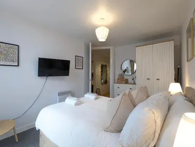 a bedroom with a white bed and a flat screen tv at City Centre Morden 1-Bedroom Apt Near Dock in Liverpool