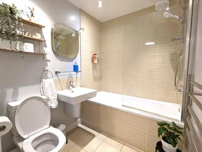 a bathroom with a toilet and a sink and a tub at City Centre Morden 1-Bedroom Apt Near Dock in Liverpool