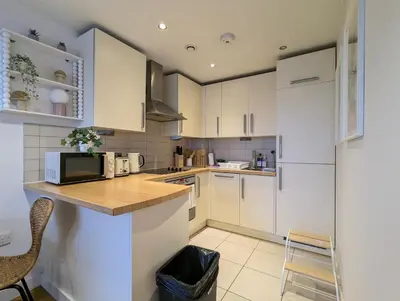 a kitchen with white cabinets and a counter top at City Centre Morden 1-Bedroom Apt Near Dock in Liverpool