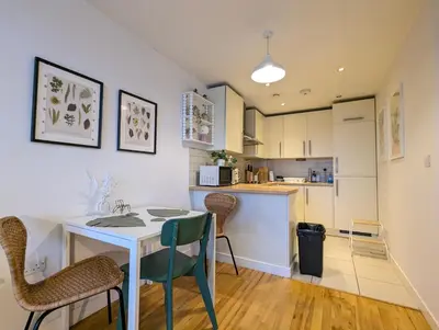 a kitchen and dining room with a table and chairs at City Centre Morden 1-Bedroom Apt Near Dock in Liverpool