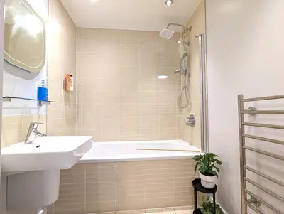 a bathroom with a sink and a bath tub at City Centre Morden 1-Bedroom Apt Near Dock in Liverpool