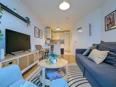 a living room with a blue couch and a tv at City Centre Morden 1-Bedroom Apt Near Dock in Liverpool