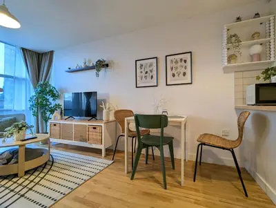 a living room with a table and chairs and a television at City Centre Morden 1-Bedroom Apt Near Dock in Liverpool