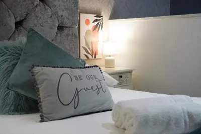 a bed with a pillow with the words be our guest at Align Lux Apartments, Liverpool City Centre in Liverpool