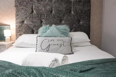 a bed with a pillow that says be our guest at Align Lux Apartments, Liverpool City Centre in Liverpool
