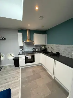 a kitchen with white cabinets and black counter tops at Align Lux Apartments, Liverpool City Centre in Liverpool