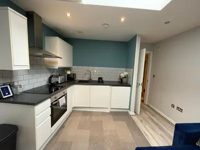 a kitchen with white cabinets and black counter tops at Align Lux Apartments, Liverpool City Centre in Liverpool