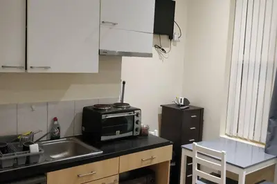 a small kitchen with a sink and a microwave at LFC Stadium Apartment 1 in Liverpool