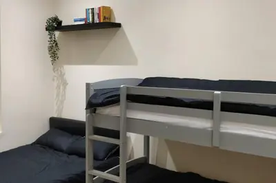 a bedroom with two bunk beds and a shelf at LFC Stadium Apartment 1 in Liverpool